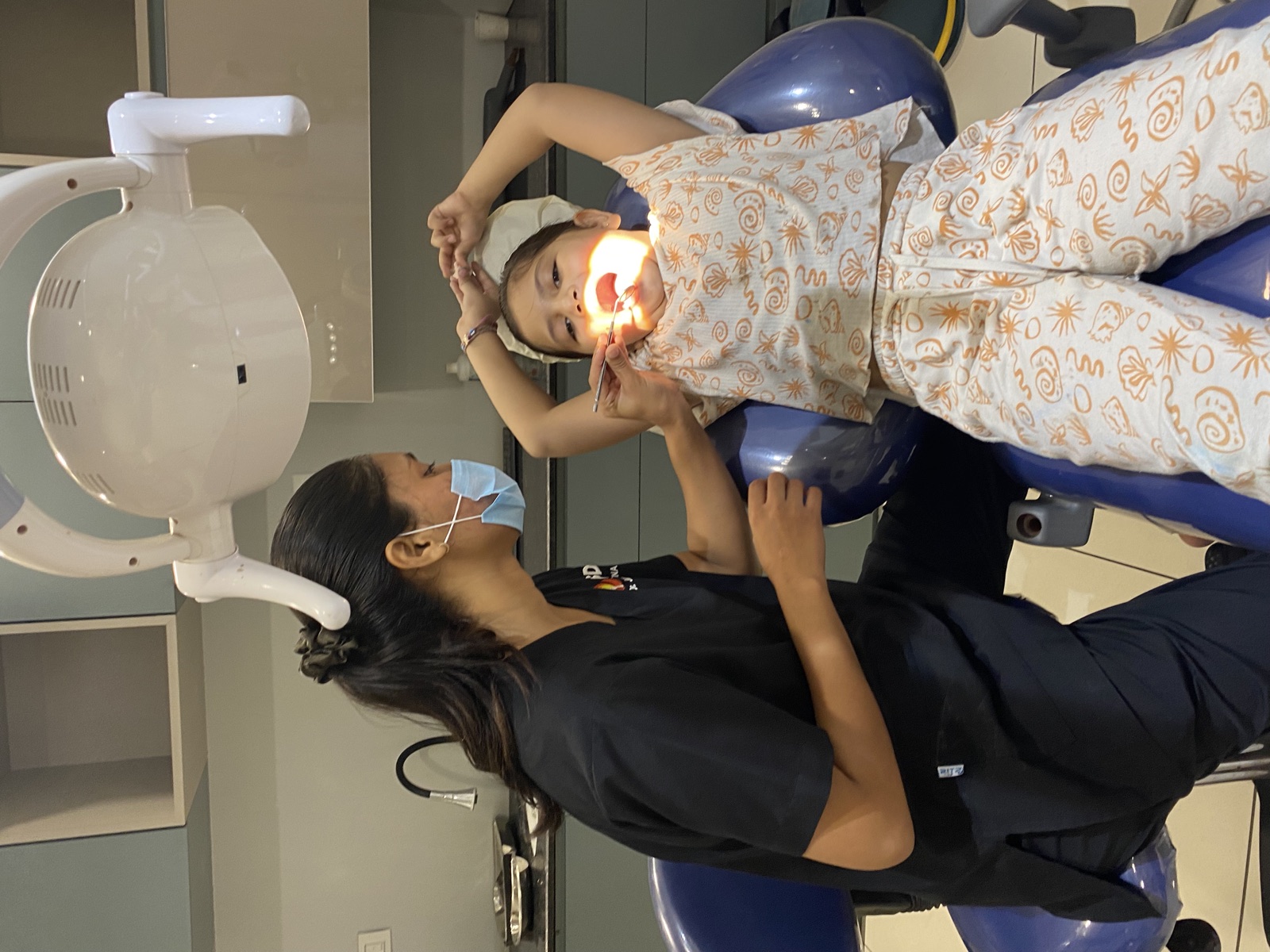 Mid-treatment: child calm and cooperative in the chair — behaviour-first protocol prioritises trust and comfort over speed.